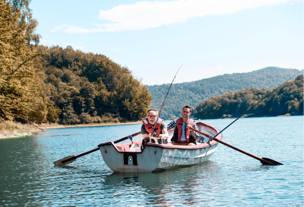 People rowing a boat on a lake surrounded by hills