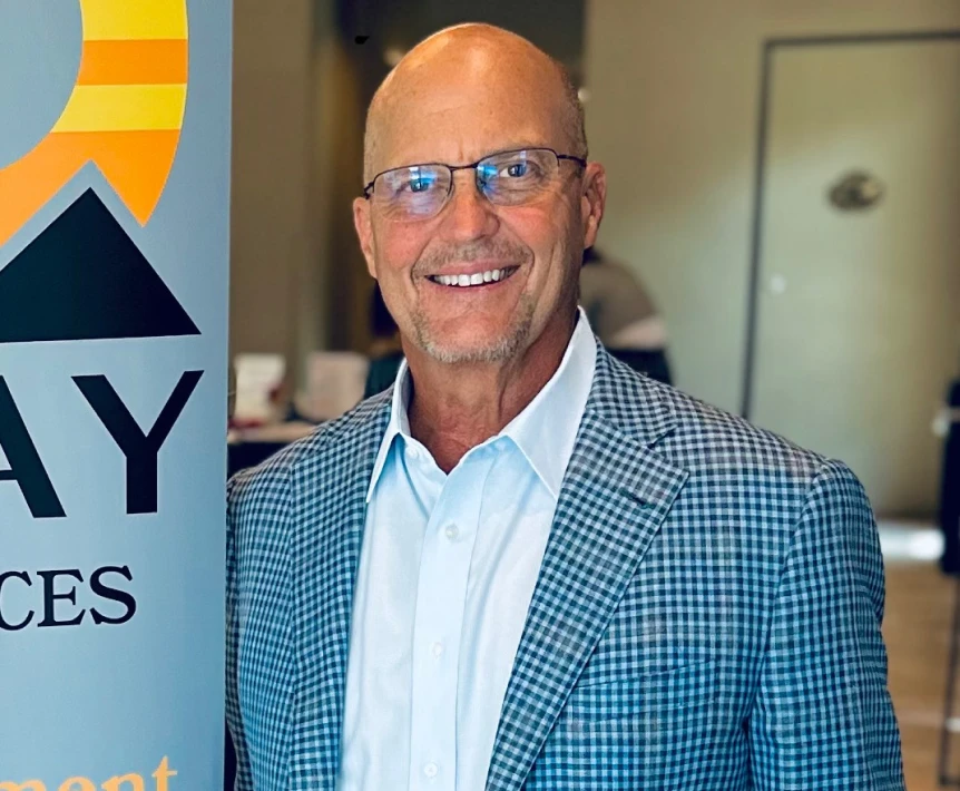 Ben Hammond smiling at New Day Recovery event in professional attire.