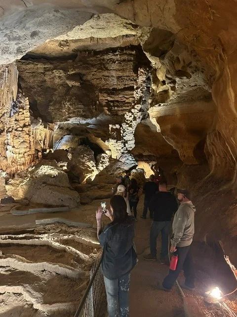 Group exploring a cavern on an outing