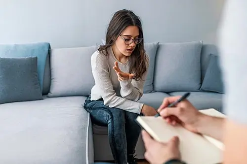 Woman explaining her situation while a counselor takes notes