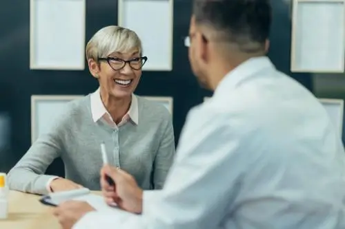 Smiling older woman talking with a doctor