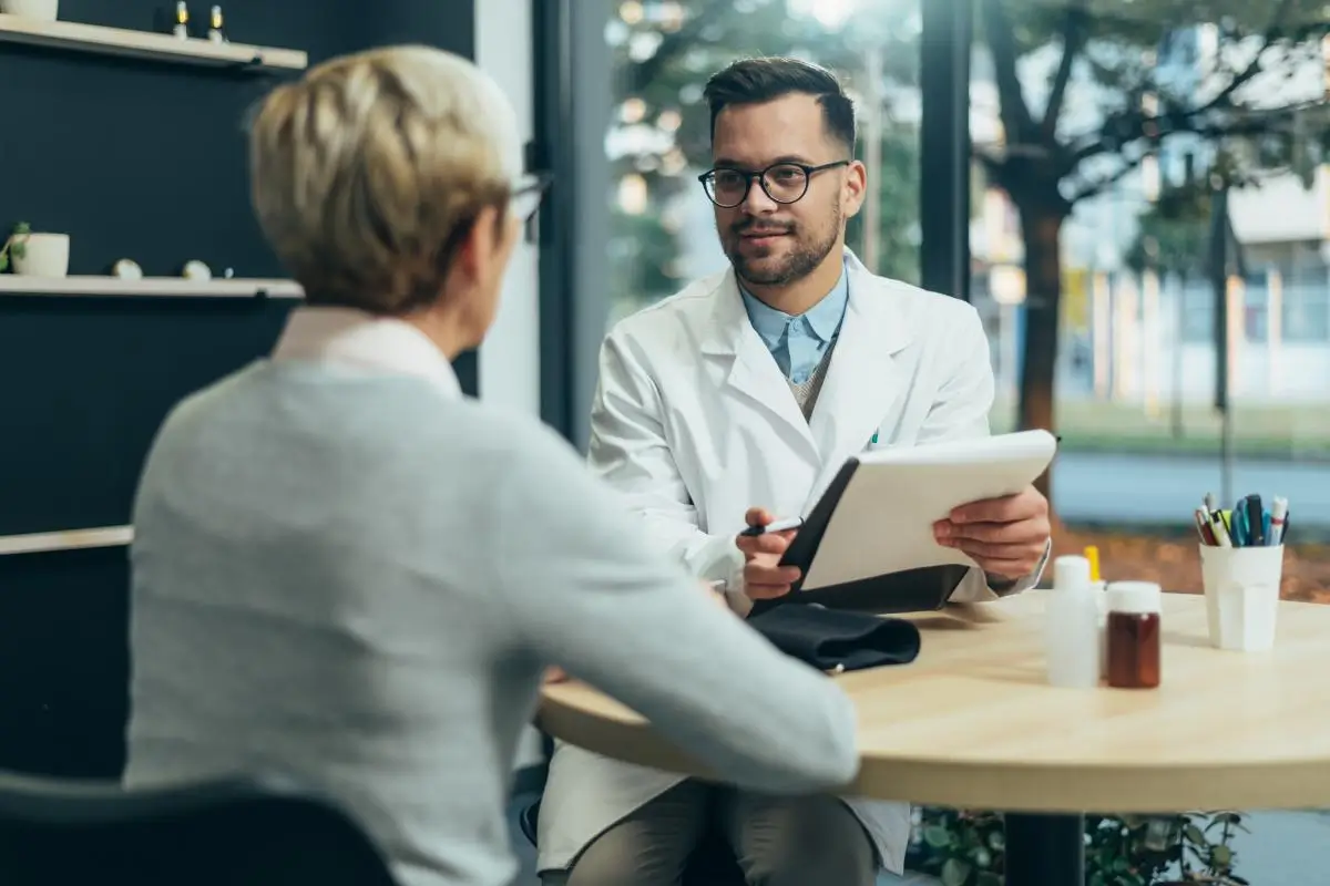 Doctor with a tablet discussing medication with an older woman