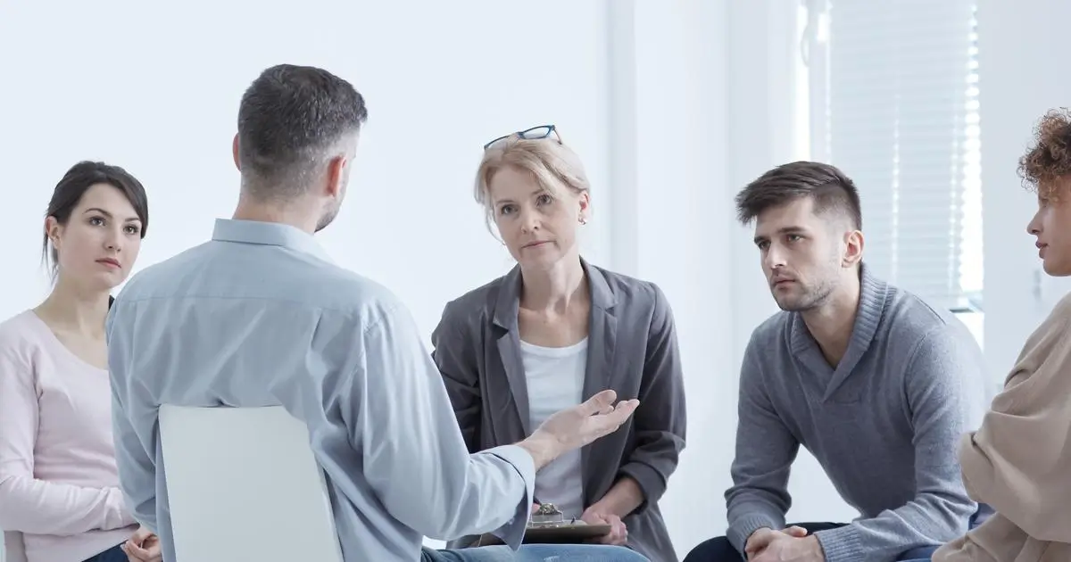 Adults in discussion during a standing group session