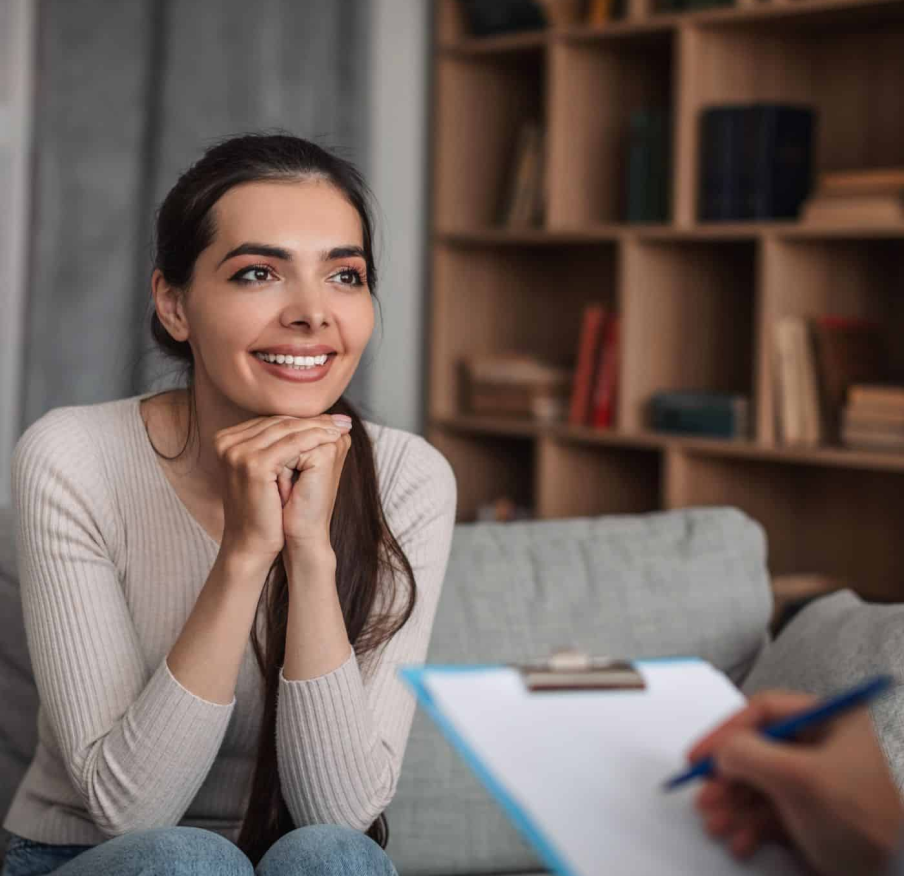 Smiling woman resting her chin on her hands during a counseling session