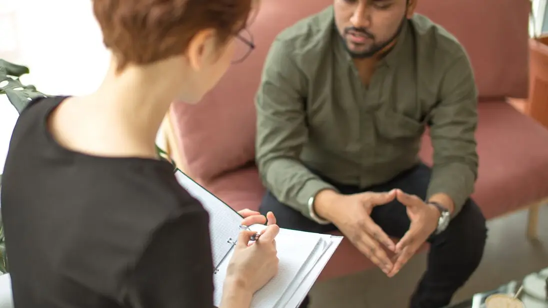Counselor talking through symptoms with a young man