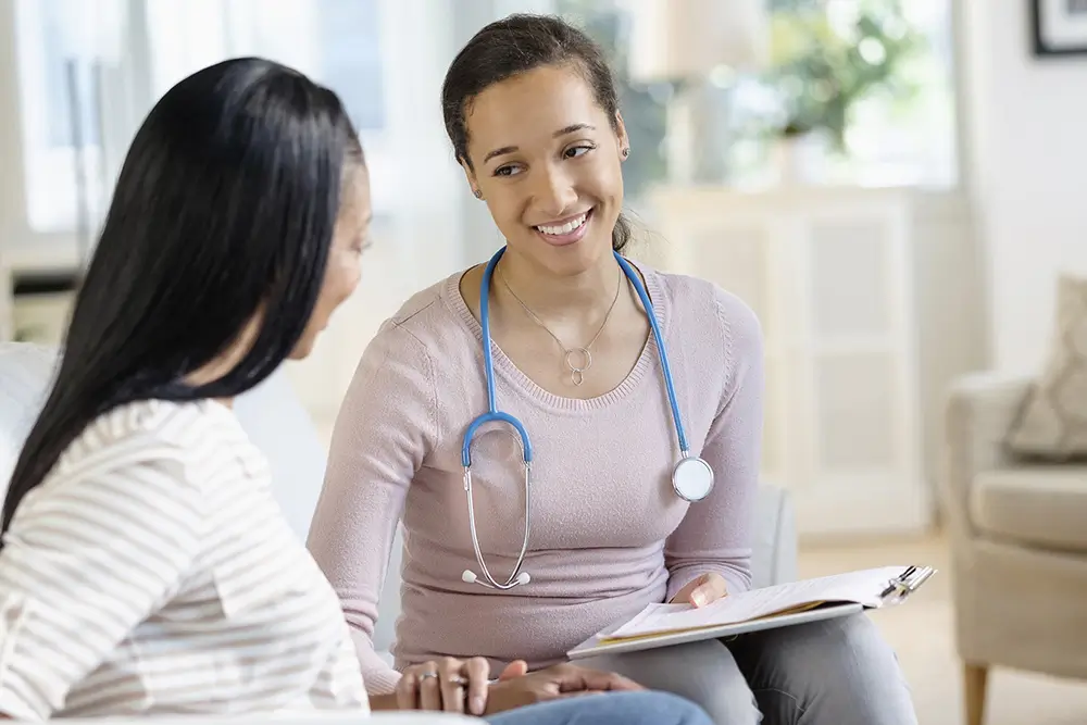 Nurse smiling while talking with a patient and family member