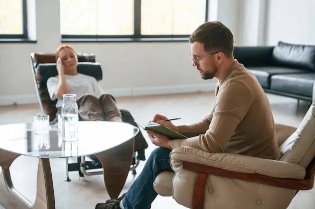 Two men in a counseling session taking notes