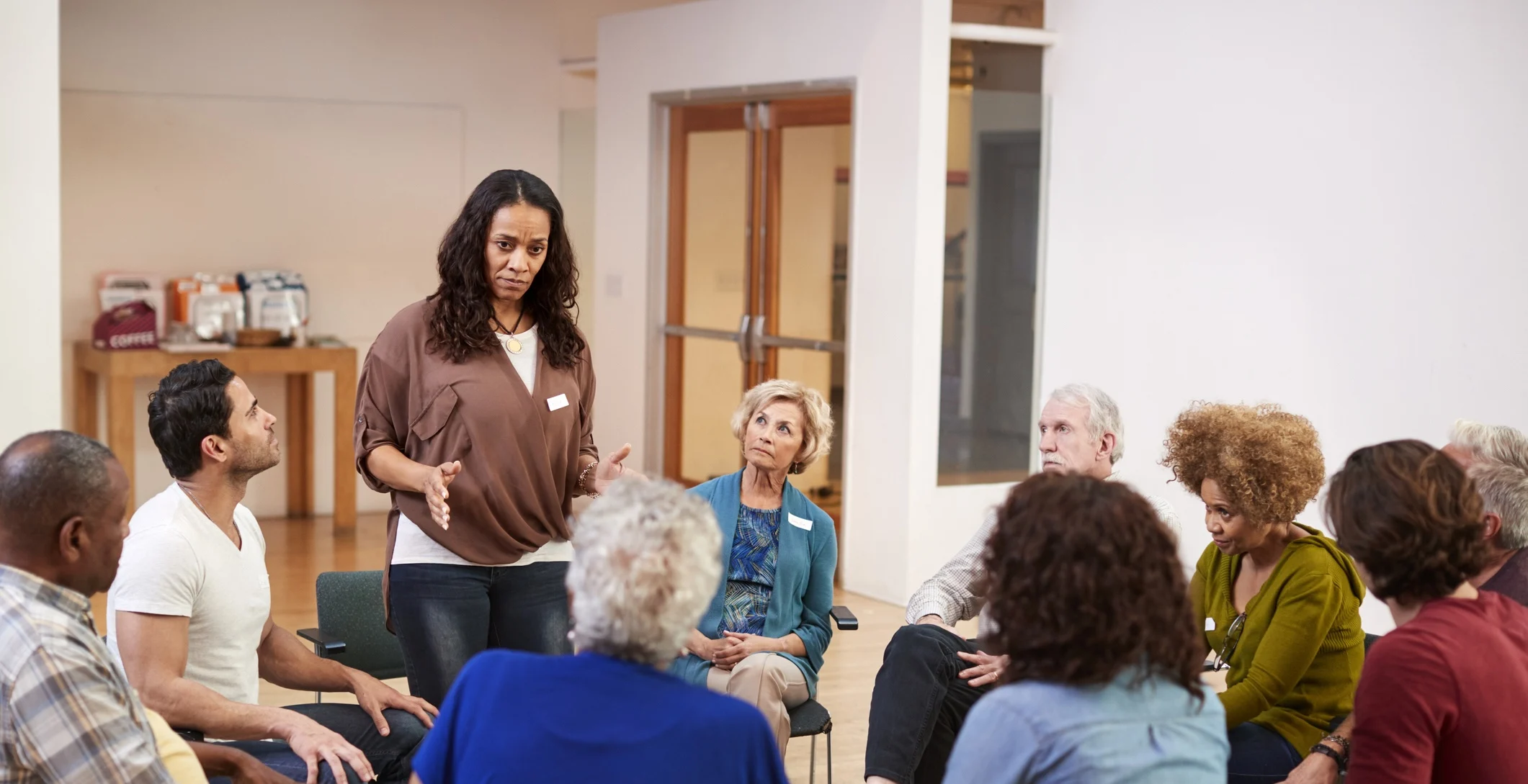 Woman speaking to a group therapy circle