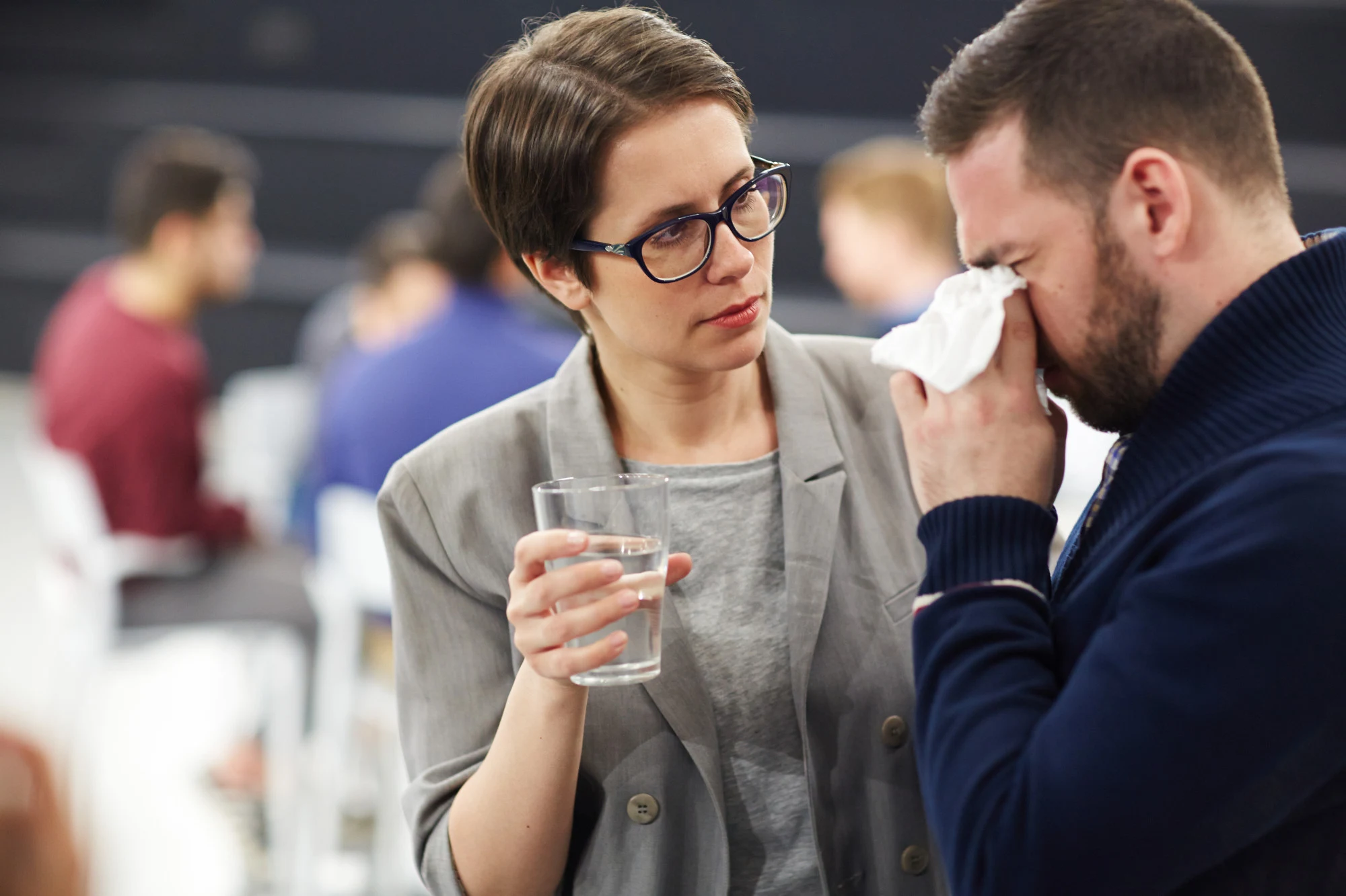 Woman comforting a tearful man at a support group