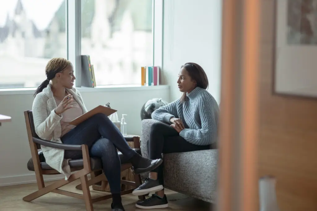Two women talking in armchairs during a counseling session