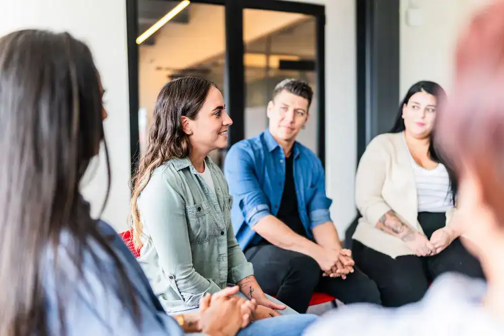 Group therapy members listening to a speaker