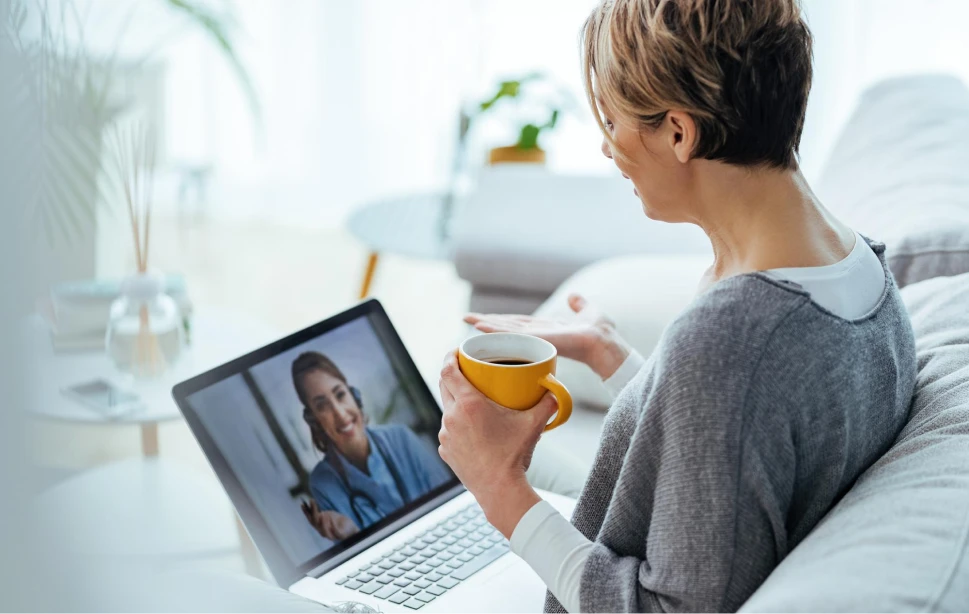 Woman having a telehealth video call with a doctor on a laptop