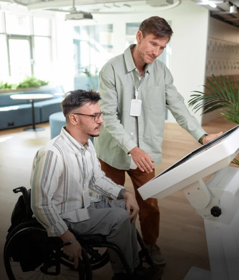 Staff member assisting a man using a wheelchair