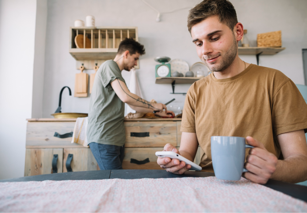 Two men preparing food and talking in a shared kitchen