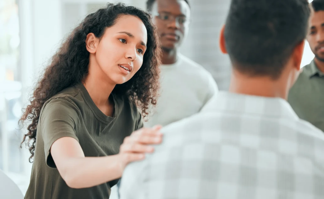 Young woman reaching out supportively in a group session