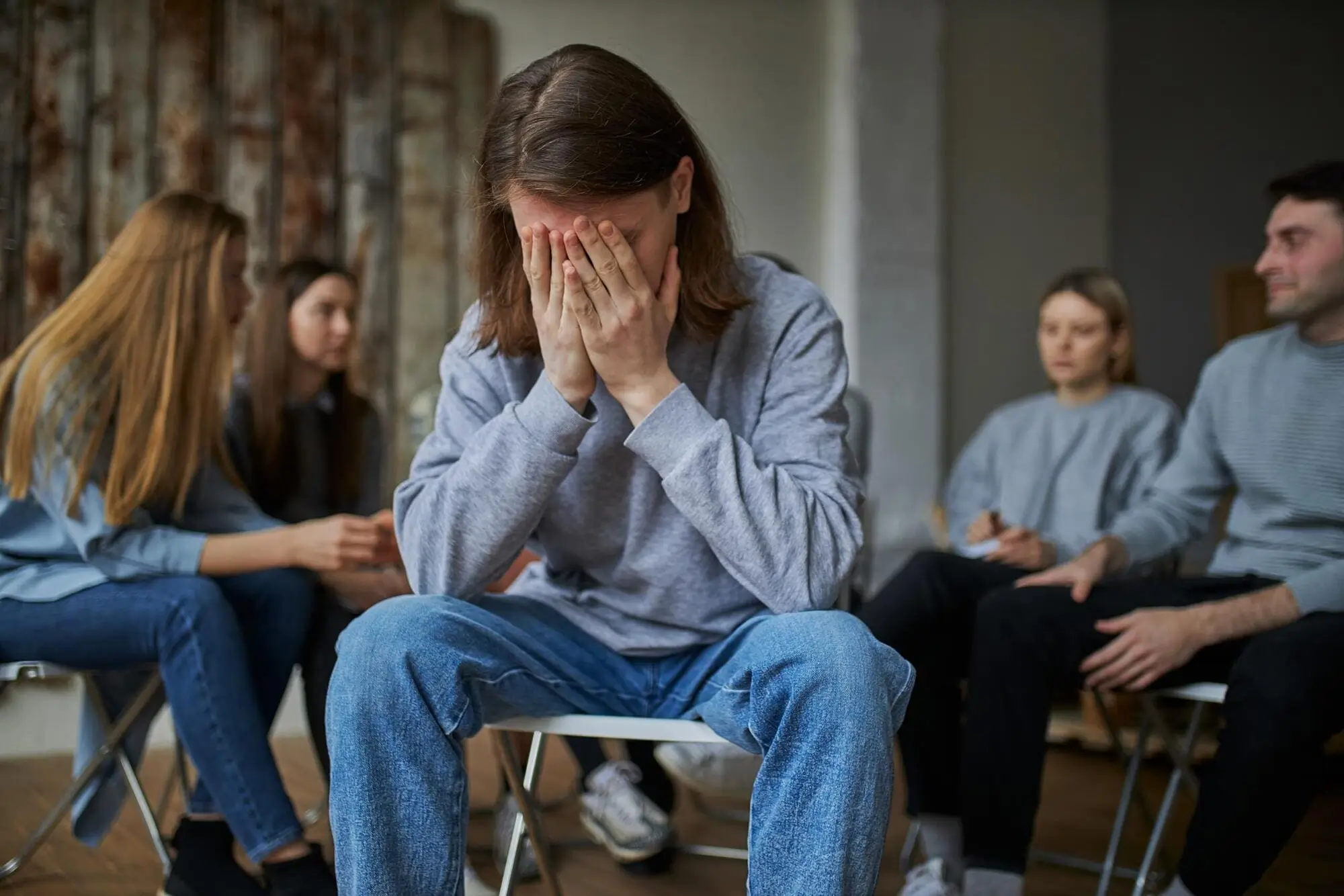 Man covering his face during an emotional group session