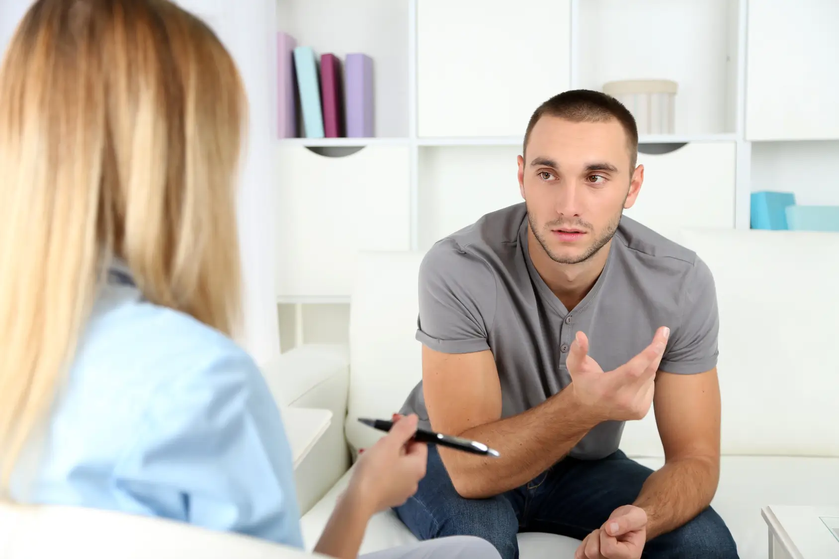 Young man talking with a counselor taking notes