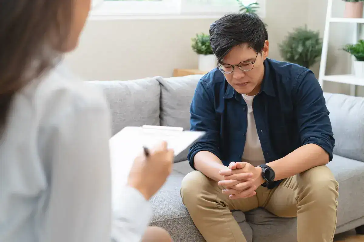 Counselor with a clipboard talking with a young man