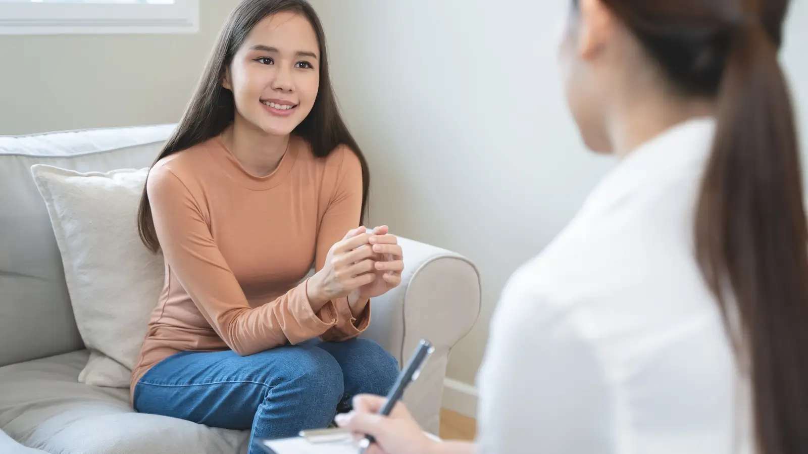 Smiling young woman talking with a counselor