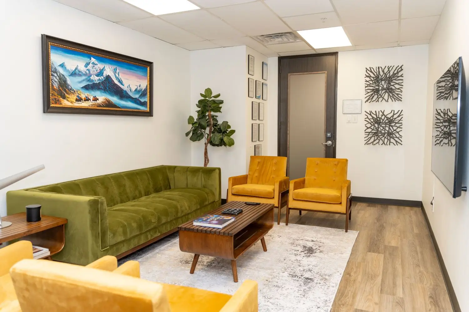 Waiting room with green couch and mountain artwork