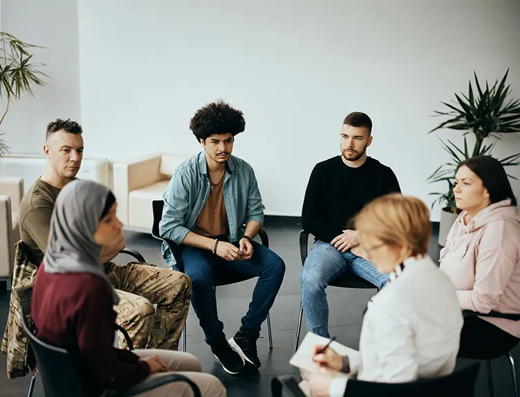 Young adults seated in a circle during a group therapy session