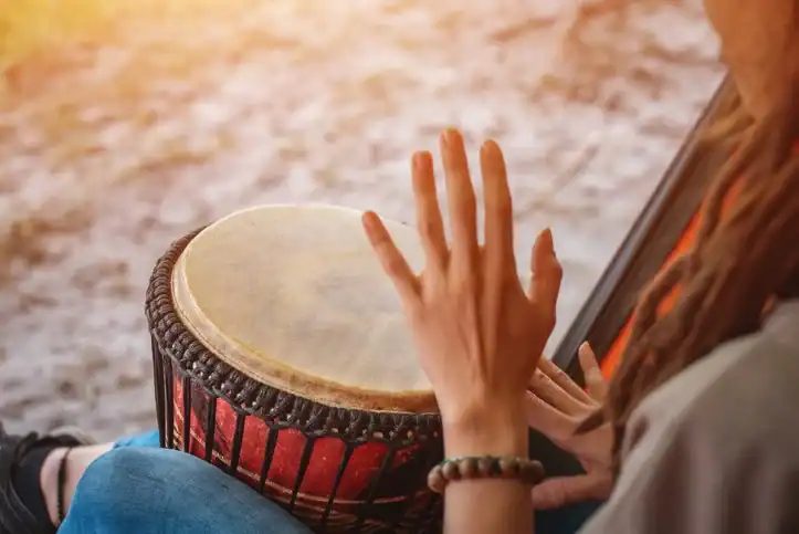 Hands playing a drum during a music therapy session