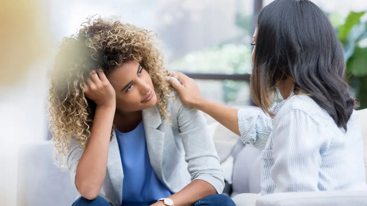 Woman comforting another woman during a support session