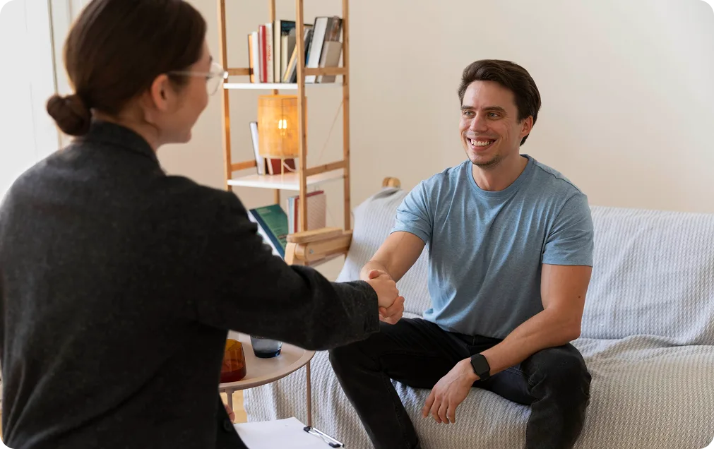 Counselor shaking hands with a smiling man