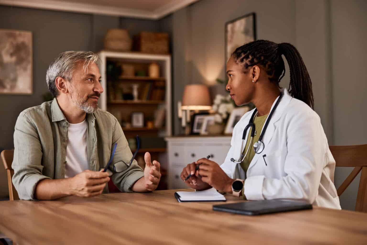 A doctor speaking with a patient at a table.